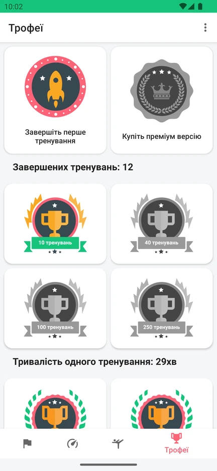 Екран «Трофеї» в застосунку: нагороди за кількість завершених тренувань і за тривалість тренування.